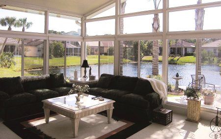 A sunroom overlook a canal on a sunny day