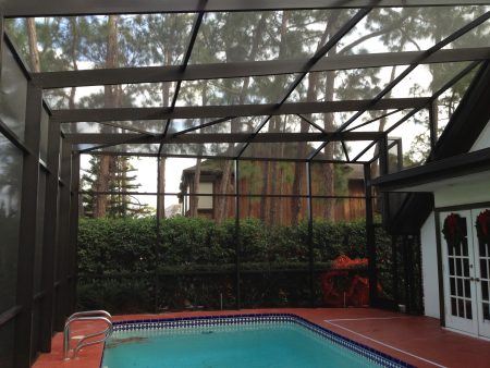 A picture of a pool cage in front of the house